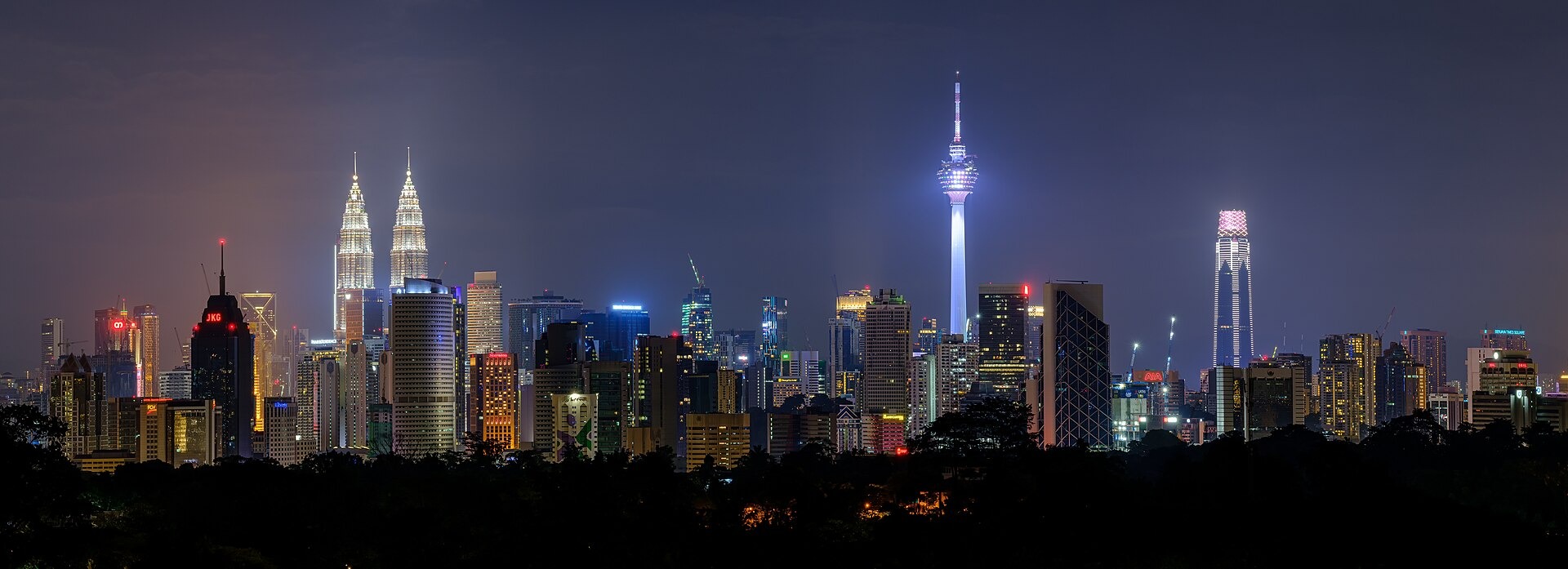 The Kuala Lumpur skyline at night, with the Petronas Twin Towers and KL Tower lit up