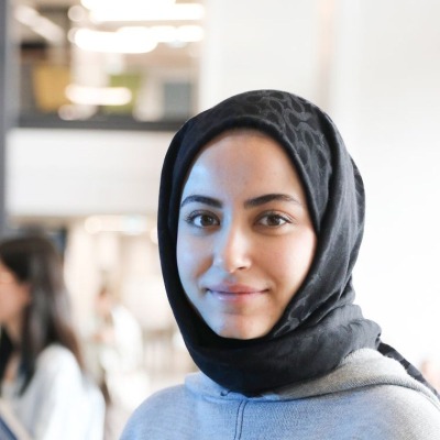 Nusrat Jahan, a student in a black headscarf, smiling in a university building