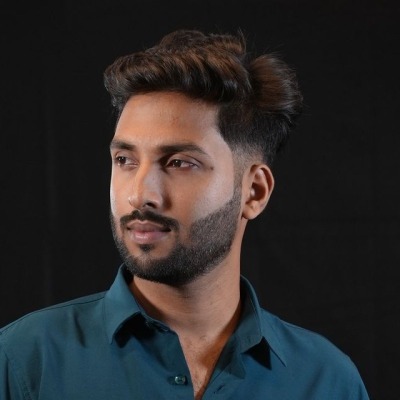 Rafiq Hasan, a young man in a teal shirt, against a dark background